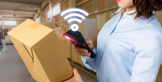 Young,Woman,Holding,Handy,Terminal,And,Box.,Smart,Logistics,Concept.