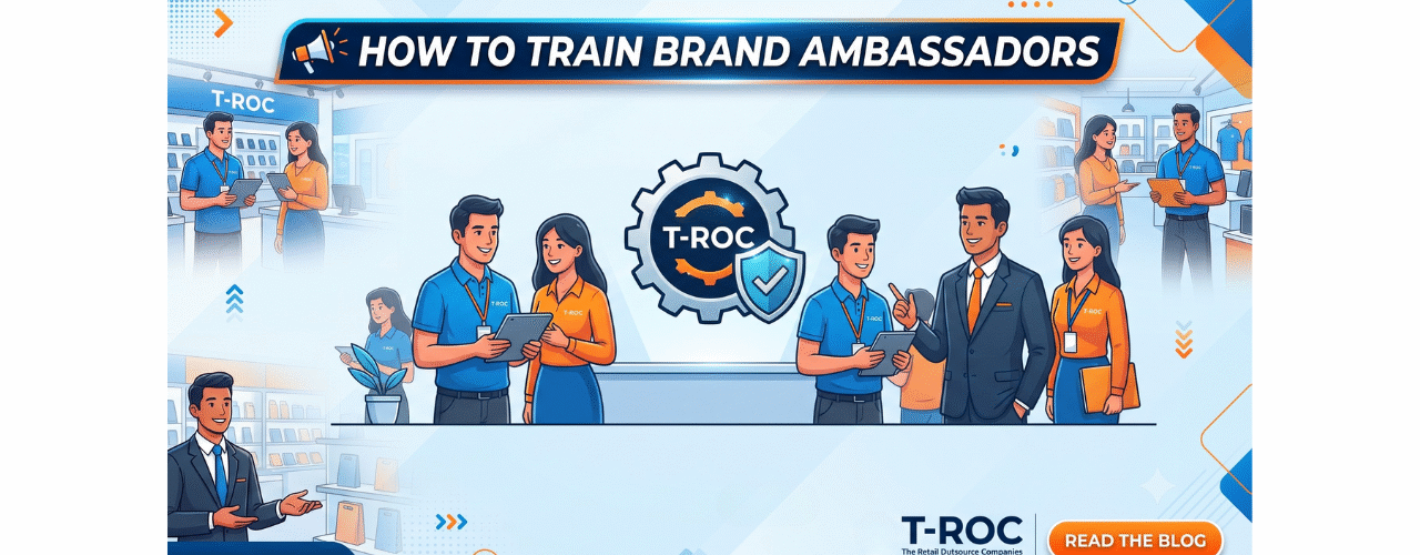 A clean, horizontal blog banner with a modern light blue and orange tech-retail theme. In the center, a gear icon encloses the T-ROC logo alongside a blue security shield checkmark, representing structured training and brand alignment. On either side, diverse brand ambassadors in T-ROC uniforms are shown collaborating, using tablets, and learning in a retail environment. The top header prominently displays "HOW TO TRAIN BRAND AMBASSADORS," while the bottom features the official T-ROC logo and a "READ THE BLOG" call-to-action button.